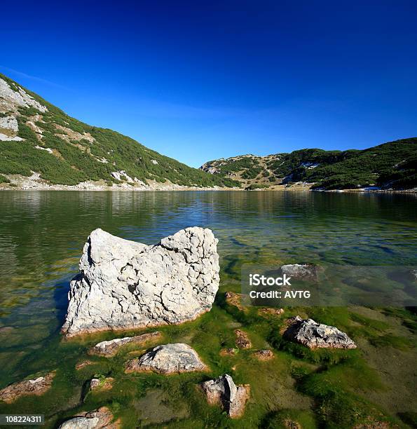 Lago De Montaña Con Moss Rocas Cubiertas Y Cielo Azul Foto de stock y más banco de imágenes de Aire libre