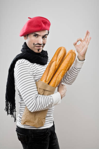 frenchman mit französischem baguette - französische kultur stock-fotos und bilder