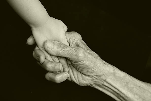 istock Senior Person's Gripping Child's Hand, Black and White 108224600