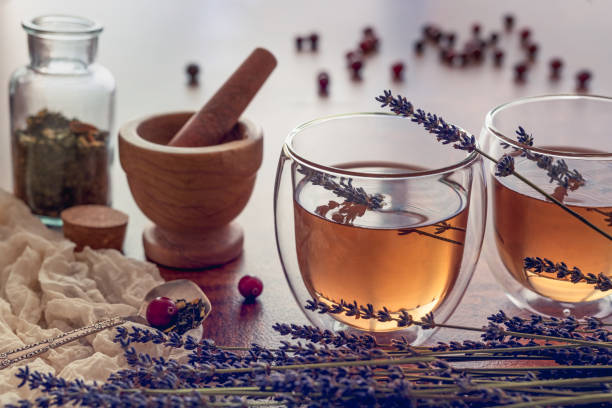 herbata ziołowa w szklanej filiżance z lawendą i suchymi owocami na drewnianym stole kuchennym - dry tea zdjęcia i obrazy z banku zdjęć