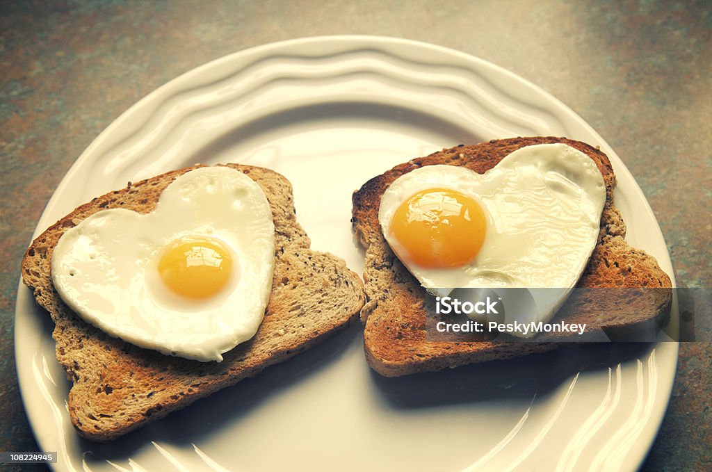 Corazón en forma de huevos sobre tostadas para dos - Foto de stock de Al día siguiente de la fiesta libre de derechos