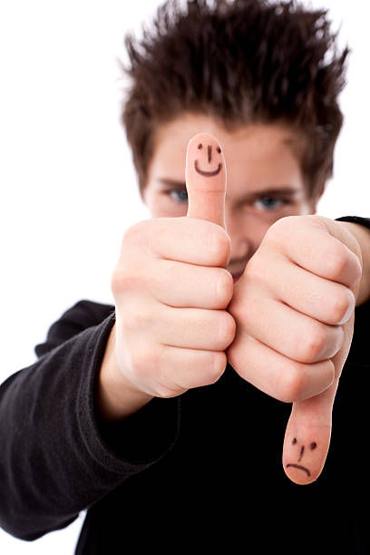 Rule of thumbs.Positive and negative gesture with smile sign. Taken in studio with Canon Eos 1DS Mark 3
