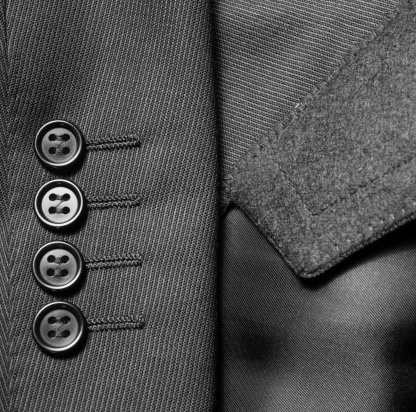 Detail closeup close-up of suit button hole fabric on sleeve of blazer jacket