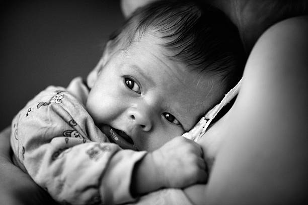 Black and White Portrait of Baby Boy Lying on Mother stock photo