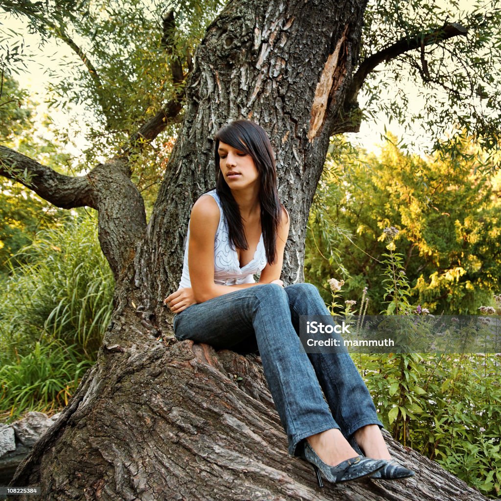 Porträt der jungen Frau sitzt auf Baum - Lizenzfrei Abwarten Stock-Foto