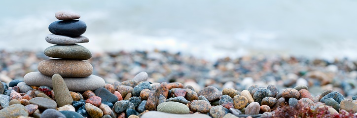 Panoramic shot of pebble stones on the sea beach