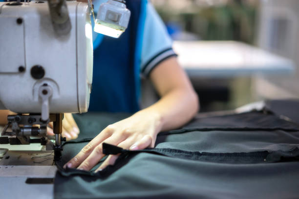 manos de niña en la máquina de coser de taller. - garment factory fotografías e imágenes de stock