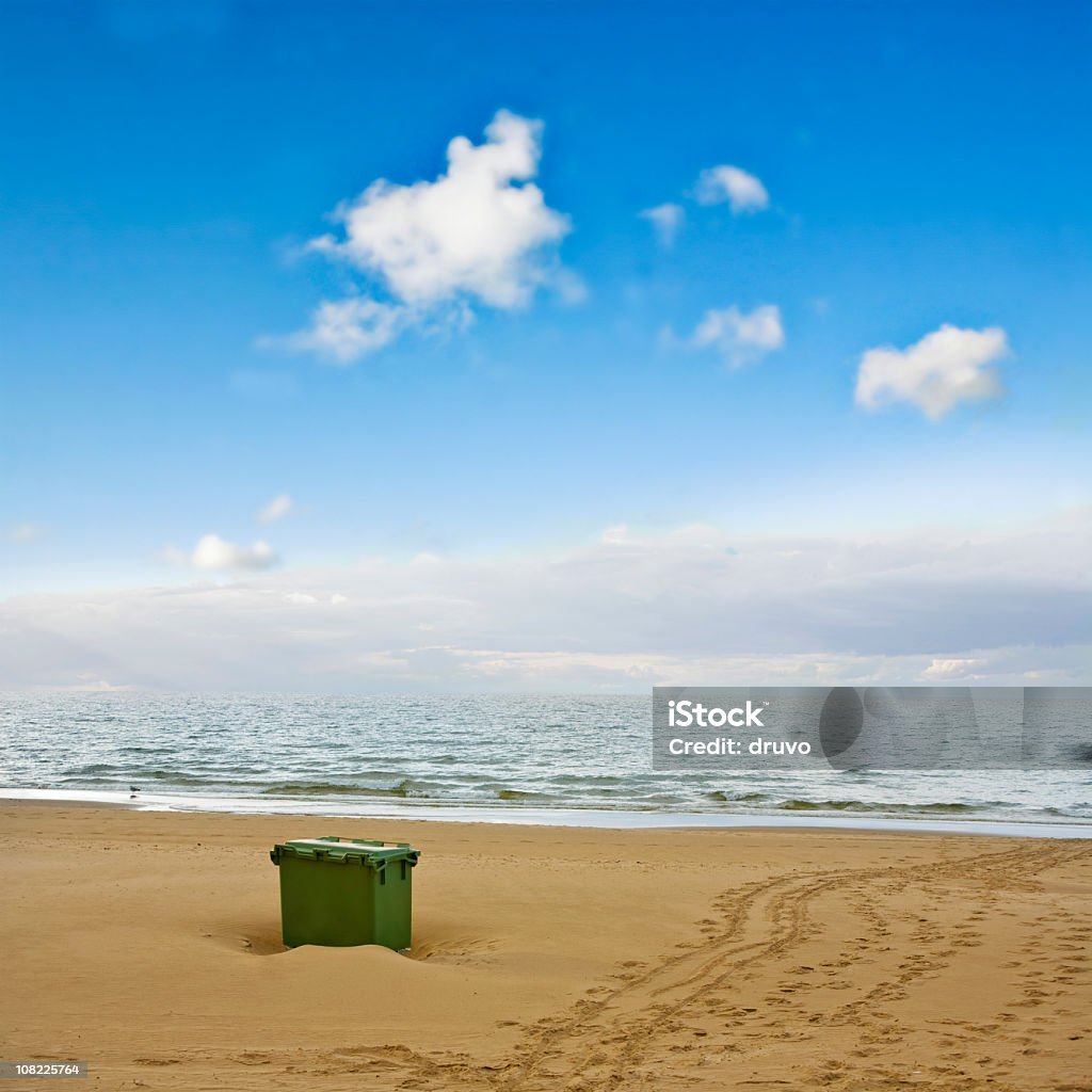 Bidone per il riciclaggio sulla spiaggia con cielo blu sfondo - Foto stock royalty-free di Impronta del piede