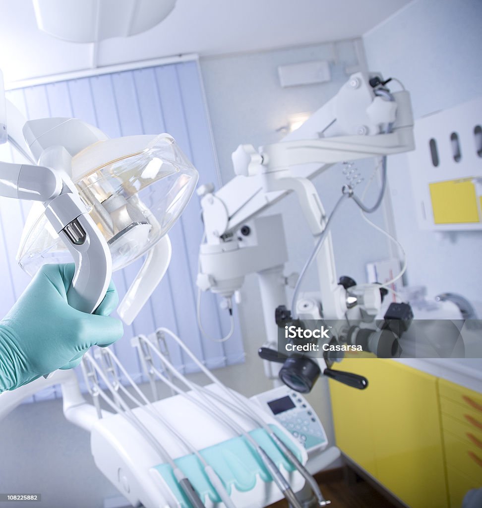 Dentist Clinic Patient Room with Gloved Hand Holding Light  Curtain Stock Photo