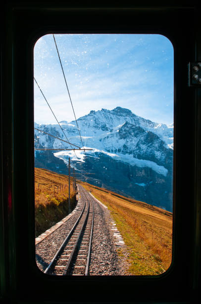 pico de jungfrau a través de la ventana del tren en la ruta de la estación de kleine scheidegg - interlaken railroad station train rural scene fotografías e imágenes de stock