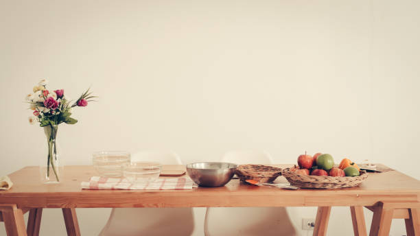 Fruits tray, tablet and orange juice on table with white wall.