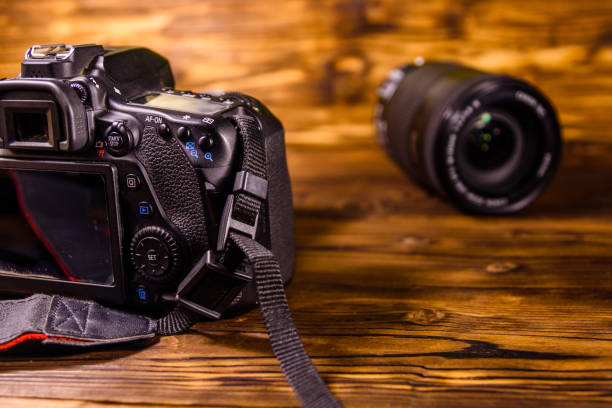 istock Modern dslr camera and lenses on wooden table 1082262280