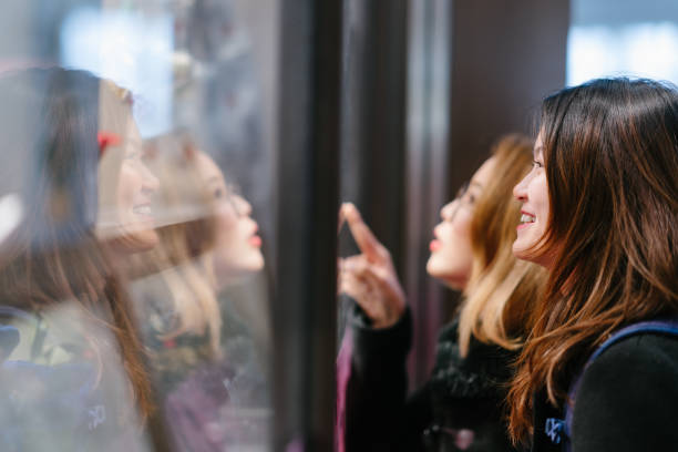 istock Two young Asian female tourists doing windowshopping 1082262772