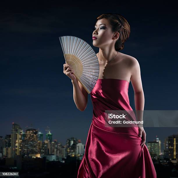 Joven Mujer Asiática Fanning Ella Fondo Panorámica A Bangkok Foto de stock y más banco de imágenes de Abanico