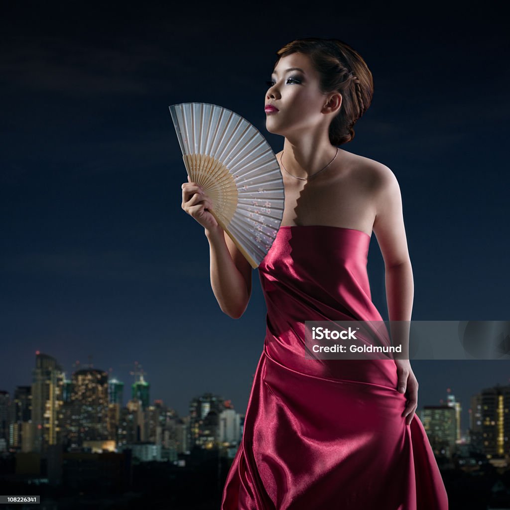Giovane asiatica donna Fanning sé, sfondo Skyline di Bangkok - Foto stock royalty-free di A spalle scoperte