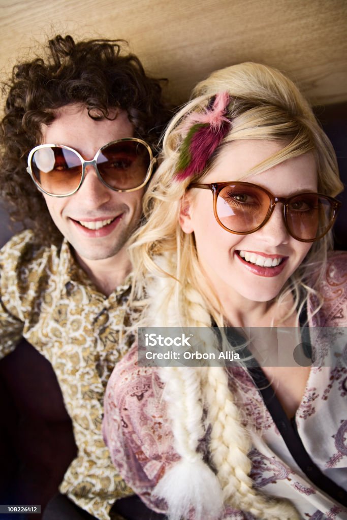 Giovane donna con uomo sorridente indossando grandi occhiali da sole rétro - Foto stock royalty-free di Relazione di coppia