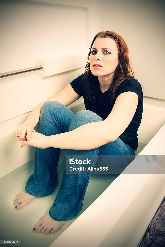 Traurig Ein deprimierter Frau sitzt in einer Badewanne mit Wasser - Lizenzfrei Badewanne Stock-Foto