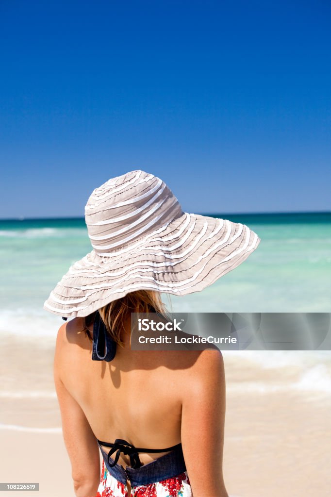 Jovem mulher com Chapéu de Sol em pé na praia - Royalty-free Adulto Foto de stock