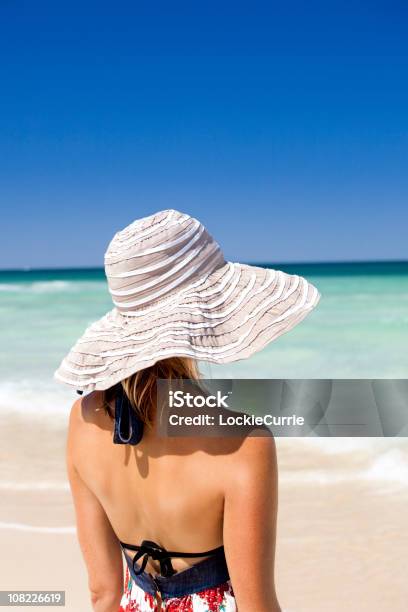 Jovem Mulher Com Chapéu De Sol Em Pé Na Praia - Fotografias de stock e mais imagens de Adulto - Adulto, Ao Ar Livre, Areia
