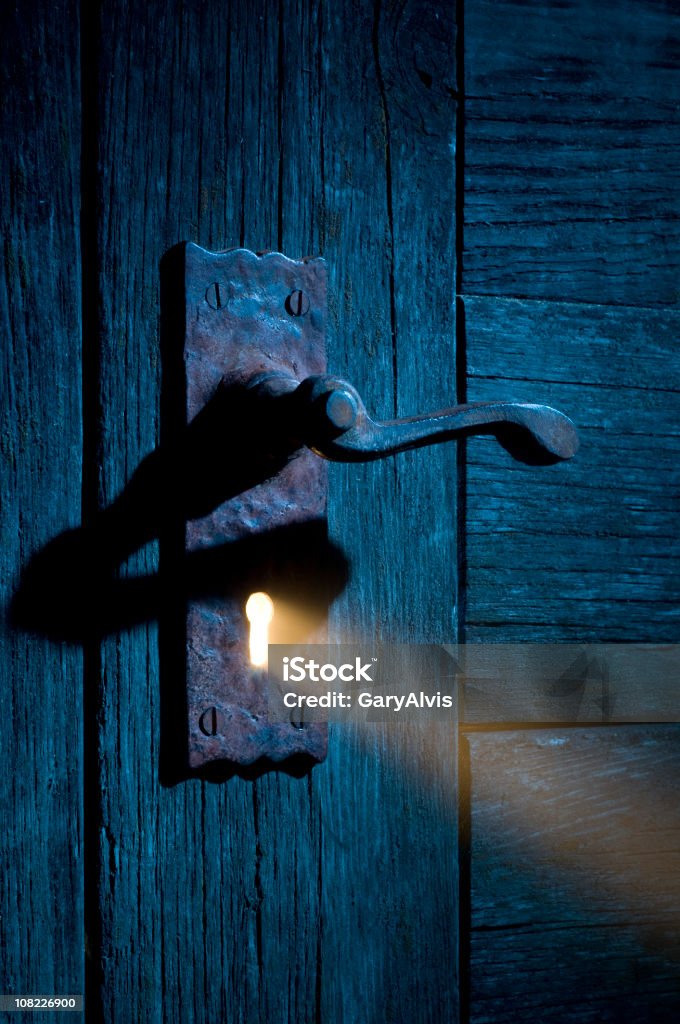 Mysterious Light Coming Through Antique Keyhole and Door  Keyhole Stock Photo