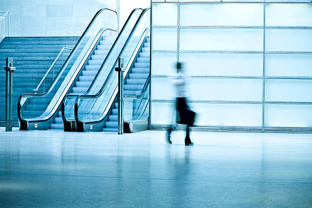 istock Businessman Walking in Blue Corridor With Escalator 108226942