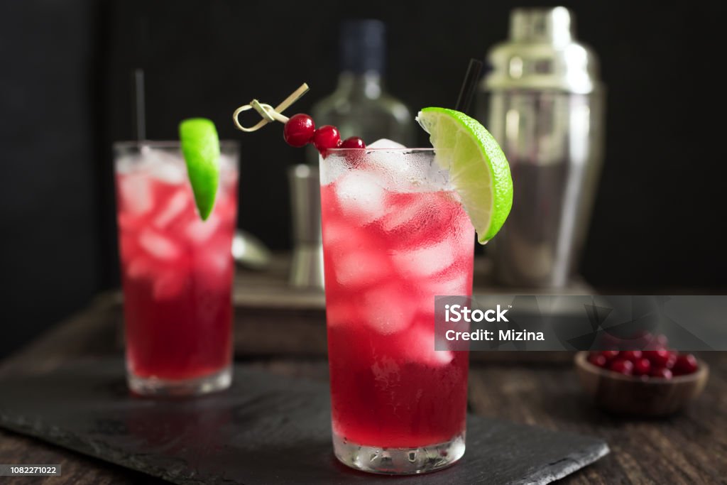 Cranberry Vodka Cocktail Cranberry Vodka Cocktail with lime and ice on black table. Cape Codder Cocktail with cranberry juice and vodka, alcohol drink. Cranberry Stock Photo