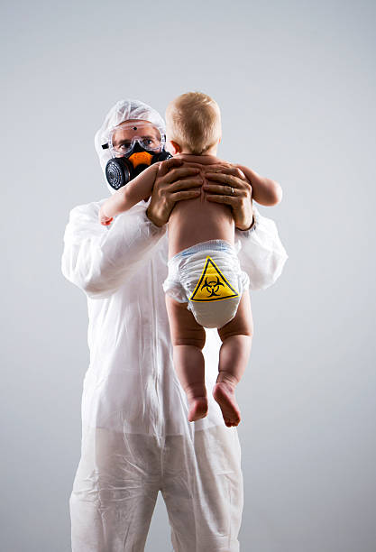 A man in a protective suit, goggles and mask holds a baby with a biohazard symbol on his diaper. Click below for related images:\n\n\n[url=file_closeup.php?id=8982274][img]file_thumbview_approve.php?size=1&id=8982274[/img][/url] [url=file_closeup.php?id=8883419][img]file_thumbview_approve.php?size=1&id=8883419[/img][/url] [url=file_closeup.php?id=8883408][img]file_thumbview_approve.php?size=1&id=8883408[/img][/url] [url=file_closeup.php?id=8881210][img]file_thumbview_approve.php?size=1&id=8881210[/img][/url] [url=file_closeup.php?id=8873757][img]file_thumbview_approve.php?size=1&id=8873757[/img][/url] [url=file_closeup.php?id=8867168][img]file_thumbview_approve.php?size=1&id=8867168[/img][/url] [url=file_closeup.php?id=8860017][img]file_thumbview_approve.php?size=1&id=8860017[/img][/url] [url=file_closeup.php?id=8843142][img]file_thumbview_approve.php?size=1&id=8843142[/img][/url] [url=file_closeup.php?id=8843139][img]file_thumbview_approve.php?size=1&id=8843139[/img][/url] [url=file_closeup.php?id=8835352][img]file_thumbview_approve.php?size=1&id=8835352[/img][/url] [url=file_closeup.php?id=8823136][img]file_thumbview_approve.php?size=1&id=8823136[/img][/url] [url=file_closeup.php?id=8814467][img]file_thumbview_approve.php?size=1&id=8814467[/img][/url]