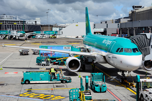 Dublin, Ireland - July 8, 2014: View of Dublin airport apron and Aer Lingus Airbus from the passenger terminal. The airplane is being prepared for passenger boarding and departure.