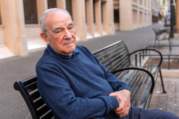 istock Old man sitting in a city bench 1082284098