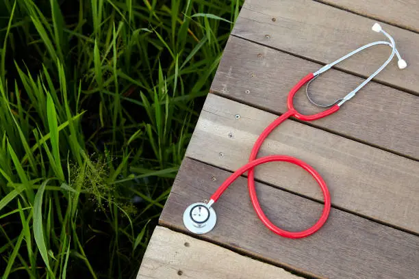 stethoscope red on wood, Concept, Doctor or medical volunteers to visit elderly people in rural Asia