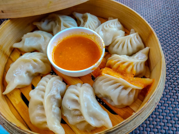 istock Chicken momo served in a wooden box. Top view 1082284622