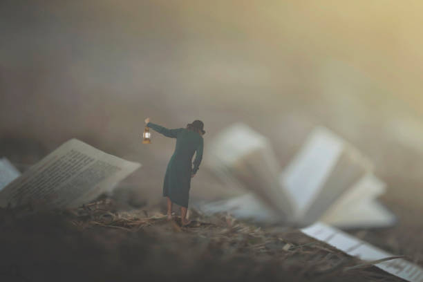 surreal moment of a woman with lantern walking confused in the fog between pages and books - nature writing women ideas imagens e fotografias de stock