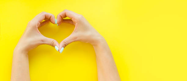 istock Heart from hands on a yellow background 1082303878