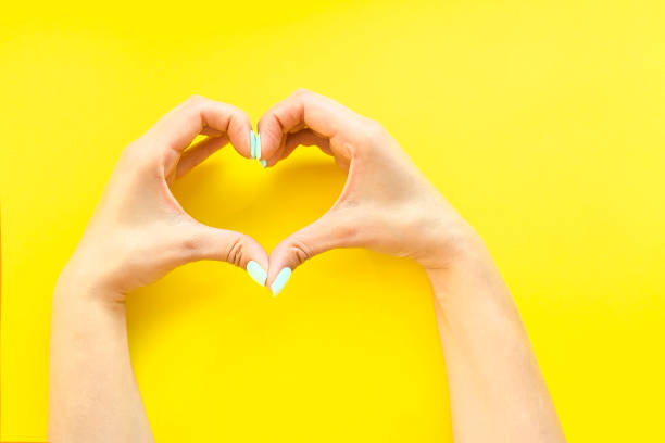 istock Heart from hands on a yellow background 1082303912