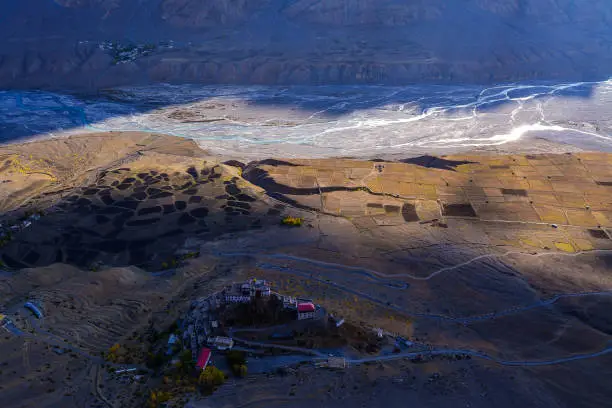The rare image of Key Monastery with its top view and Spiti valley, Spiti river, fields and a beautiful road in the background.