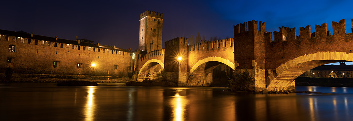 Verona, Veneto, Italy - Dec 8th, 2012: The Castelvecchio bridge (italian: Ponte di Castelvecchio) or Scaliger Bridge (Italian: Ponte Scaligero) is a fortified bridge in Verona over the Adige river, near Castelvecchio (Old Castle), the castle of Verona (UNESCO world heritage site), It is the most important military construction of the Scaliger dynasty that ruled the city in the Middle Ages. Castelvecchio is now home to the Castelvecchio Museum.