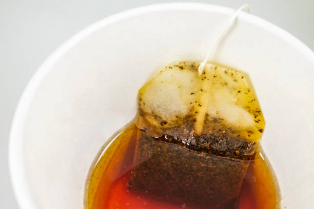 istock close up tea bag in paper cup and hot water 1082311470