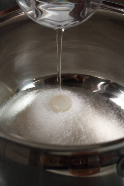 istock Add water into pan with sugar. Making Golden Syrup Series. 1082312966