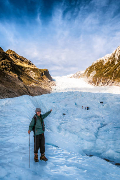 Travel image of young traveler hiking fox glacier in New Zealand Travel image of young traveler hiking fox glacier in New Zealand. Fox glacier is a popular tourist destination. Tourist sightseeing at New Zealand landscape. franz josef glacier photos stock pictures, royalty-free photos & images