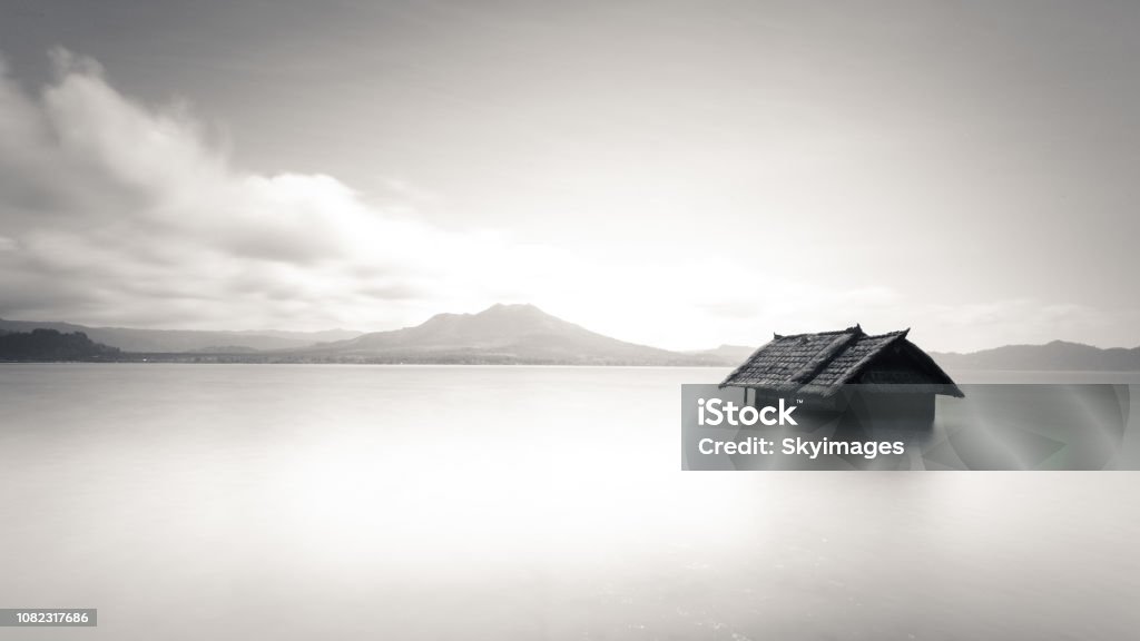 Minimalistic image of abandoned lonely house floating on water Minimalistic image of abandoned house floating on water. Clean and simple image of alone house in middle of nowhere. Simplicity photo of lonely isolated house. Peaceful serene image of lost building. Abandoned Stock Photo