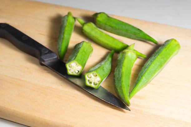 istock Green okra with kitchen knife on cutting board. 1082322624