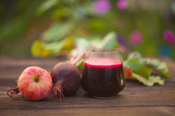 beet  juice in glass on wooden table