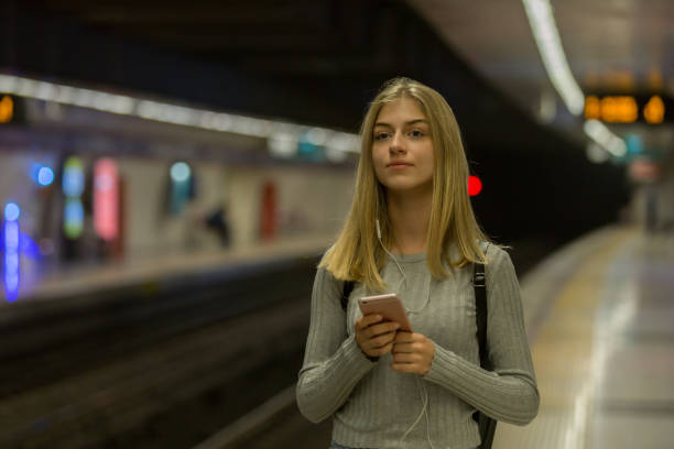 istock Young woman with phone in subway train 1082325122
