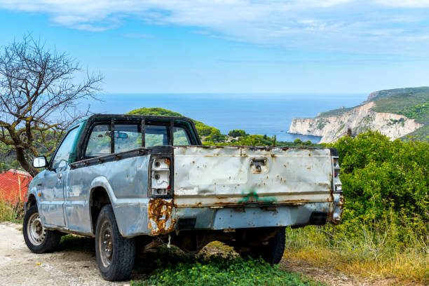 Rusty old car in front of beautiful ocean cliff landscape