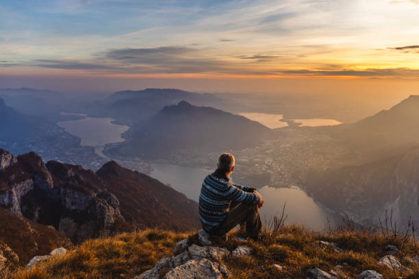 человек турист соло на горе во время золотого часа - lake como water italy sunset стоковые фото и изображения