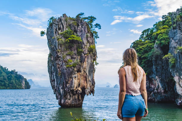 Girl in Front of Iconic Island in Phang Nga Bay, Thailand Photo of Girl in Front of Iconic Island in Phang Nga Bay, Thailand phang nga bay stock pictures, royalty-free photos & images