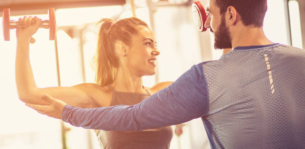 istruttore di fitness che aiuta la ragazza nell'esercizio fisico. - women weight bench exercising weightlifting foto e immagini stock