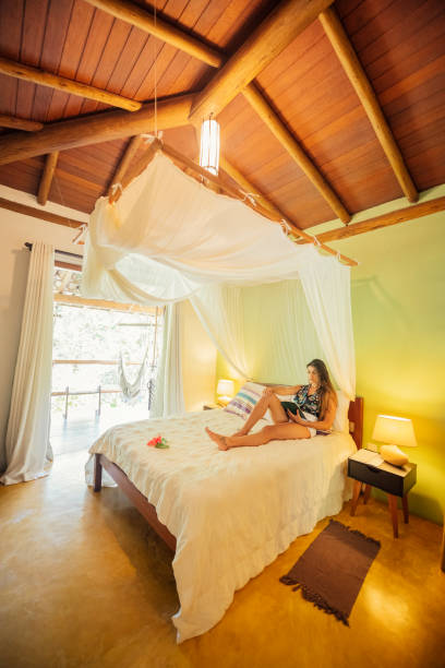 istock Woman resting on hotel bed with awning 1082344254