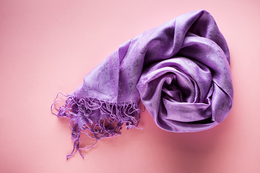 Silk scarf on a pink background, top view