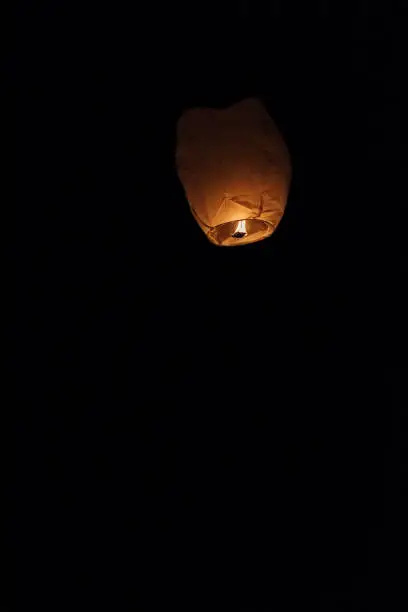 Photo of Sky lantern floating into the night sky at the festival in Pingxi, the Chinese text is a wish for money in the New Year